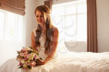 Beautiful Bride In Bedroom Sitting On Bed