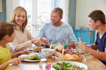 Family Enjoying Meal At Home Together