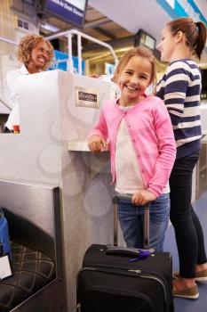 Mother And Daughter At Airport Check In Desk