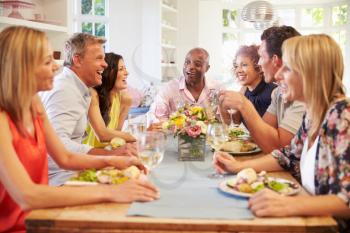 Mature Friends Sitting Around Table At Dinner Party