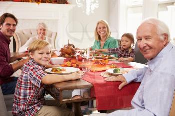 Family With Grandparents Enjoying Thanksgiving Meal At Table