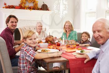 Family With Grandparents Enjoying Thanksgiving Meal At Table