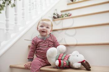 Young Girl On Stairs In Pajamas At Christmas