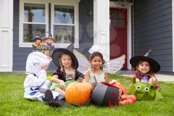 Children Dressed In Trick Or Treating Costumes On Lawn
