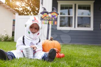 Boy Dressed In Trick Or Treating Spaceman Costume On Lawn