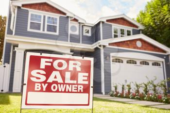 Large suburban house with for sale sign displayed outside