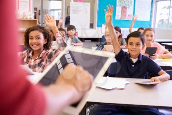 Teacher using tablet computer in elementary school lesson