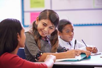 Teacher helping elementary school pupils in class