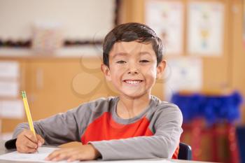 Portrait of a boy at elementary school sitting in classroom