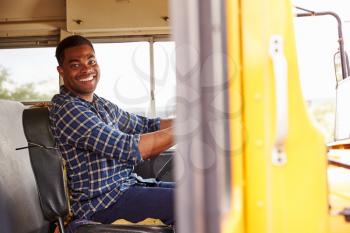 Smiling school bus driver sitting in bus
