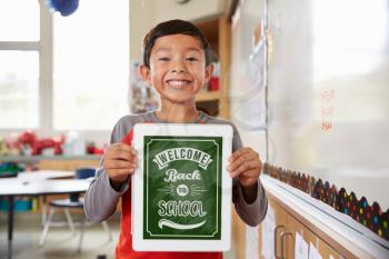 Portrait of elementary school girl holding a smart tablet