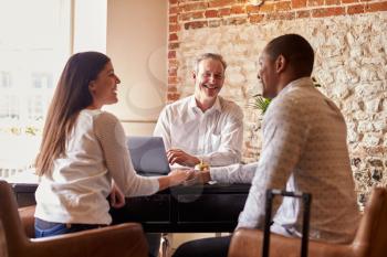 A multi ethnic couple checking in at a boutique hotel