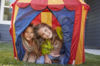 Two Children Playing Inside Tent In Garden Together