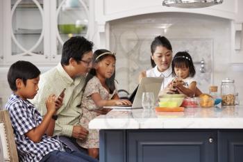 Family At Breakfast Using Digital Devices