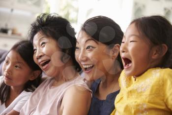 Mother With Grandmother And Granddaughters Watching TV