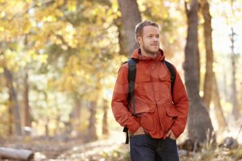 Young adult Caucasian man walking in a forest, close up