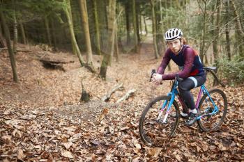 Portrait of man cross-country cycling in a forest