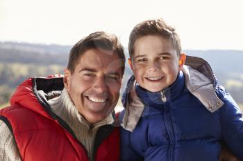 Portrait of father and son wearing coats in the countryside