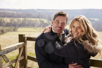 Happy couple embracing in the countryside look to camera