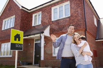 Portrait Of Young Family With Keys To New Home