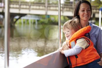 Mother And Son Enjoying Day Out In Boat On River Together