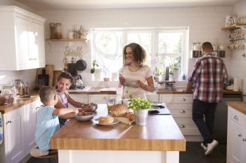 Family At Home Eating Breakfast In Kitchen Together