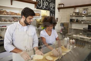 Mixed race couple work behind the counter at a sandwich bar