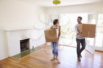 Couple Carrying Boxes Into New Home On Moving Day