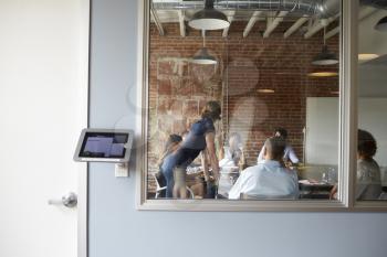 View Through Window Of Businesspeople Meeting Boardroom