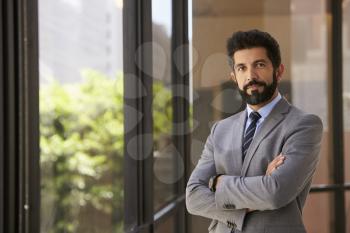 Hispanic businessman with arms crossed looking to camera