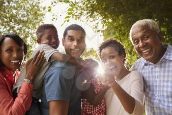 Multi generation black family in garden look to camera