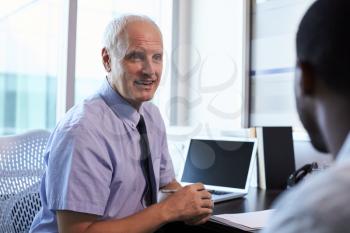 Doctor In Consultation With Male Patient In Office