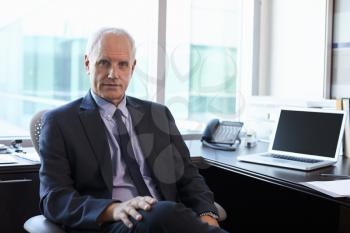 Portrait Of Doctor Sitting At Desk In Office