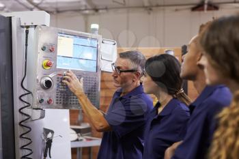 Engineer Training Apprentices On CNC Machine