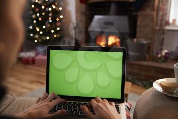 Man Using Laptop In Room Decorated For Christmas