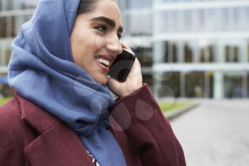 British Muslim Woman Using Mobile Phone Outside Office