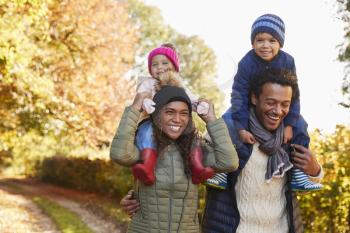 Autumn Walk With Parents Carrying Children On Shoulders