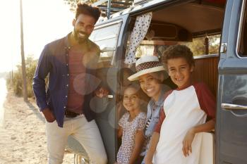 Young family make a stop on a road trip in their camper van