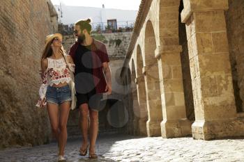 Couple sightseeing in Ibiza, looking at each other