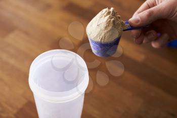 Close Up Of Man Mixing Protein Shake In Cup