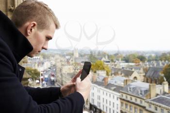 Tourist Taking Photo Of Oxford Skyline On Mobile Phone