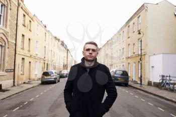 Young Man Walking Along Residential Street In Oxford