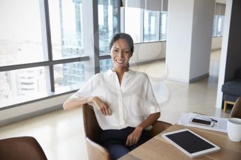 Portrait Of Businesswoman Using Digital Tablet In Boardroom