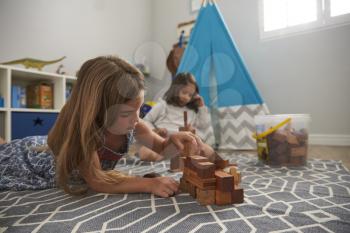 Two Girls Playing With Building Blocks In Bedroom