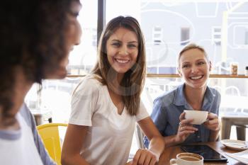 Three Female Friends Meeting In Coffee Shop