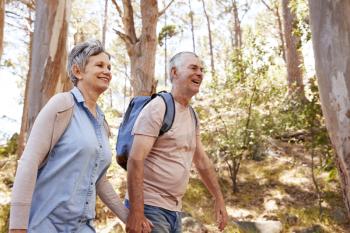 Mature Couple Hiking Along Forest Path Together