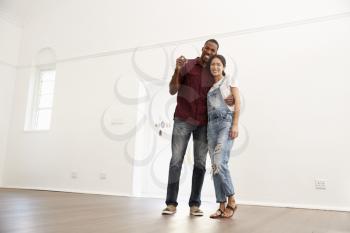 Portrait Of Excited Young Couple Moving Into New Home Together