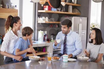 Father Having Family Breakfast In Kitchen Before Leaving For Work