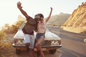 Portrait Of Young Couple Standing Next To Classic Car