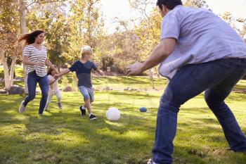 Family Playing Soccer In Park Together